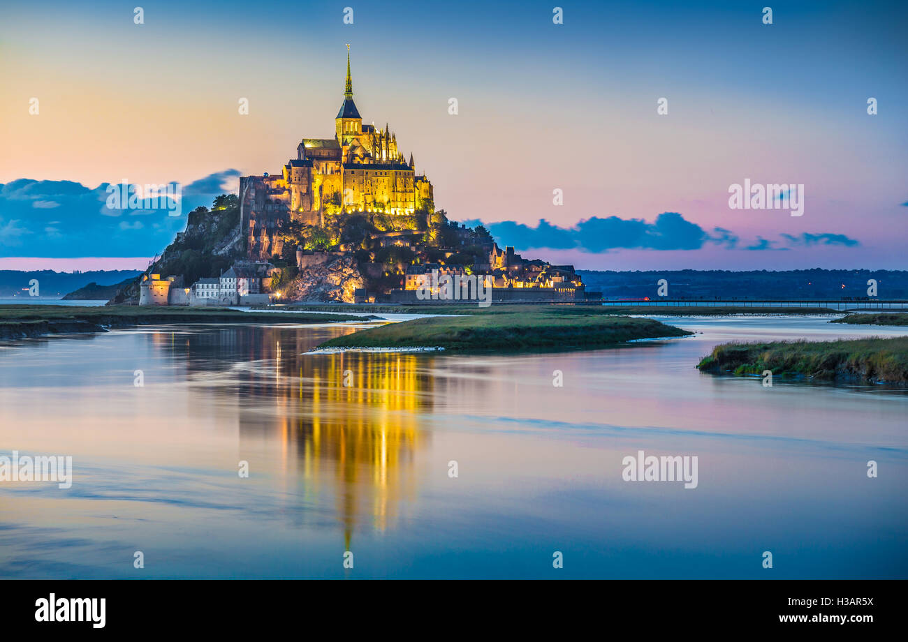 Vista clásica del famoso Le Mont Saint-Michel en la hermosa isla de marea durante la hora azul crepúsculo al atardecer, Normandía, Francia Foto de stock