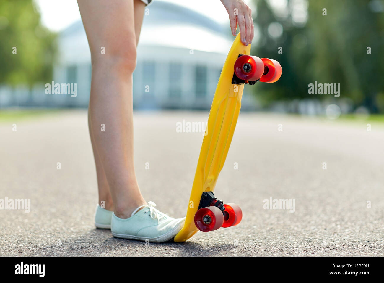Cerca de los pies femeninos con breves skateboard Foto de stock