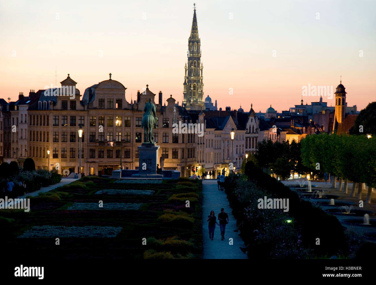 Pareja caminando en el parque y el horizonte del centro histórico de la ciudad de Bruselas, Bélgica al atardecer Foto de stock
