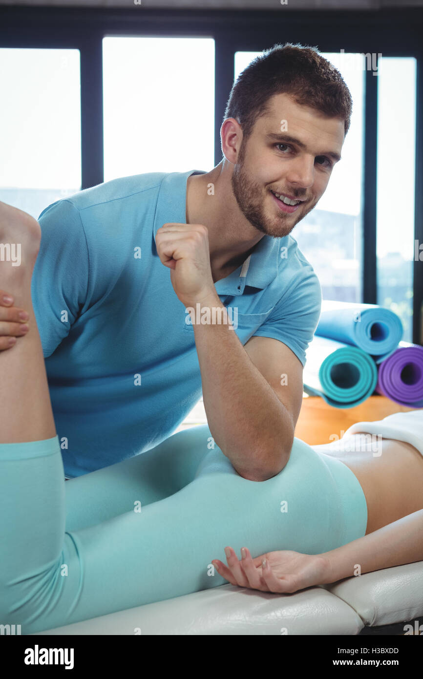 Fisioterapeuta masculino dando masaje a paciente femenina de cadera Foto de stock