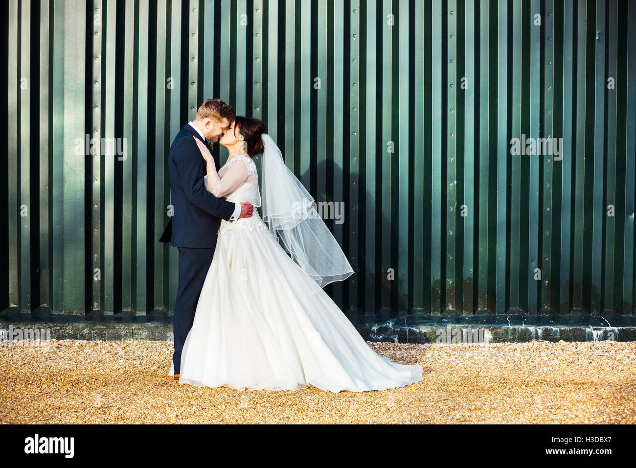 La novia y el novio en el día de su boda, besarse mutuamente. Foto de stock