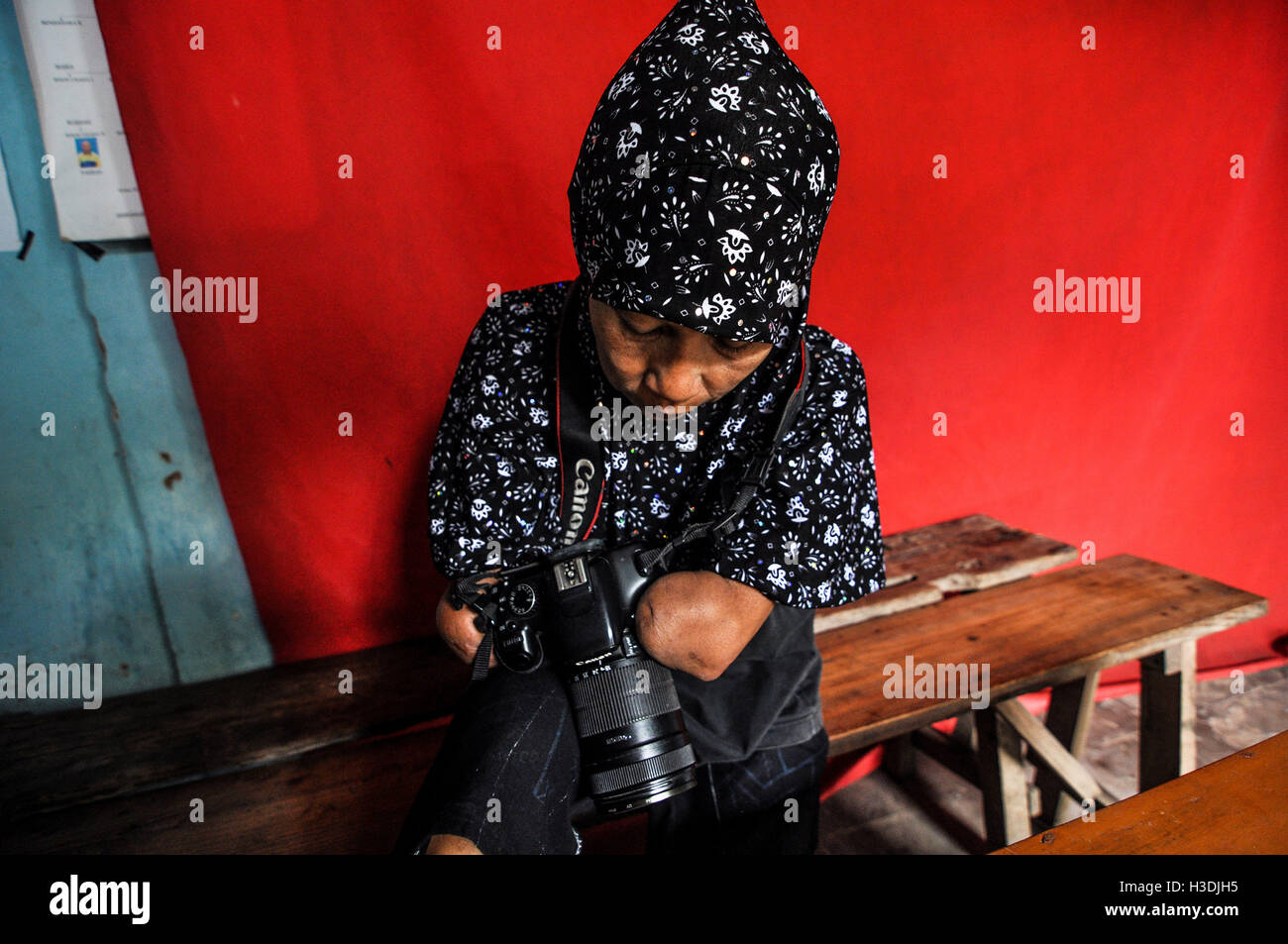 Octubre 4, 2016 - Rusidah, fotógrafos a las mujeres con discapacidad a sí  mismos como discapacitados está mirando las fotos de su trabajo, en  Purworejo, Java Central, Indonesia, Martes, 4 de octubre