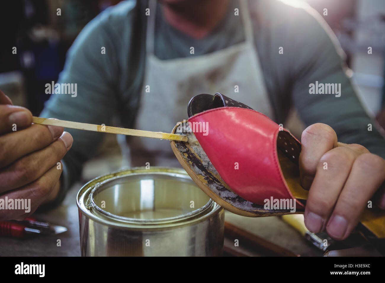 Zapatero aplicando pegamento de zapato único Fotografía de stock - Alamy