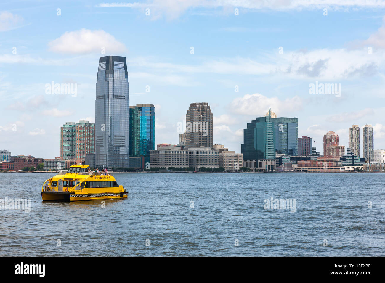 Un Taxi Acuático de Nueva York Jefes hacia el sur por el Río Hudson pasado la Torre Goldman Sachs y el horizonte de la ciudad de Jersey, Nueva Jersey. Foto de stock