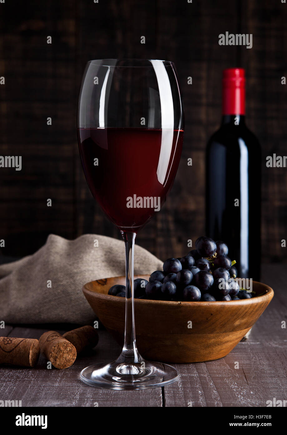 Botella y copa de vino tinto con uvas en la cubeta de la placa de madera  antecedentes Fotografía de stock - Alamy