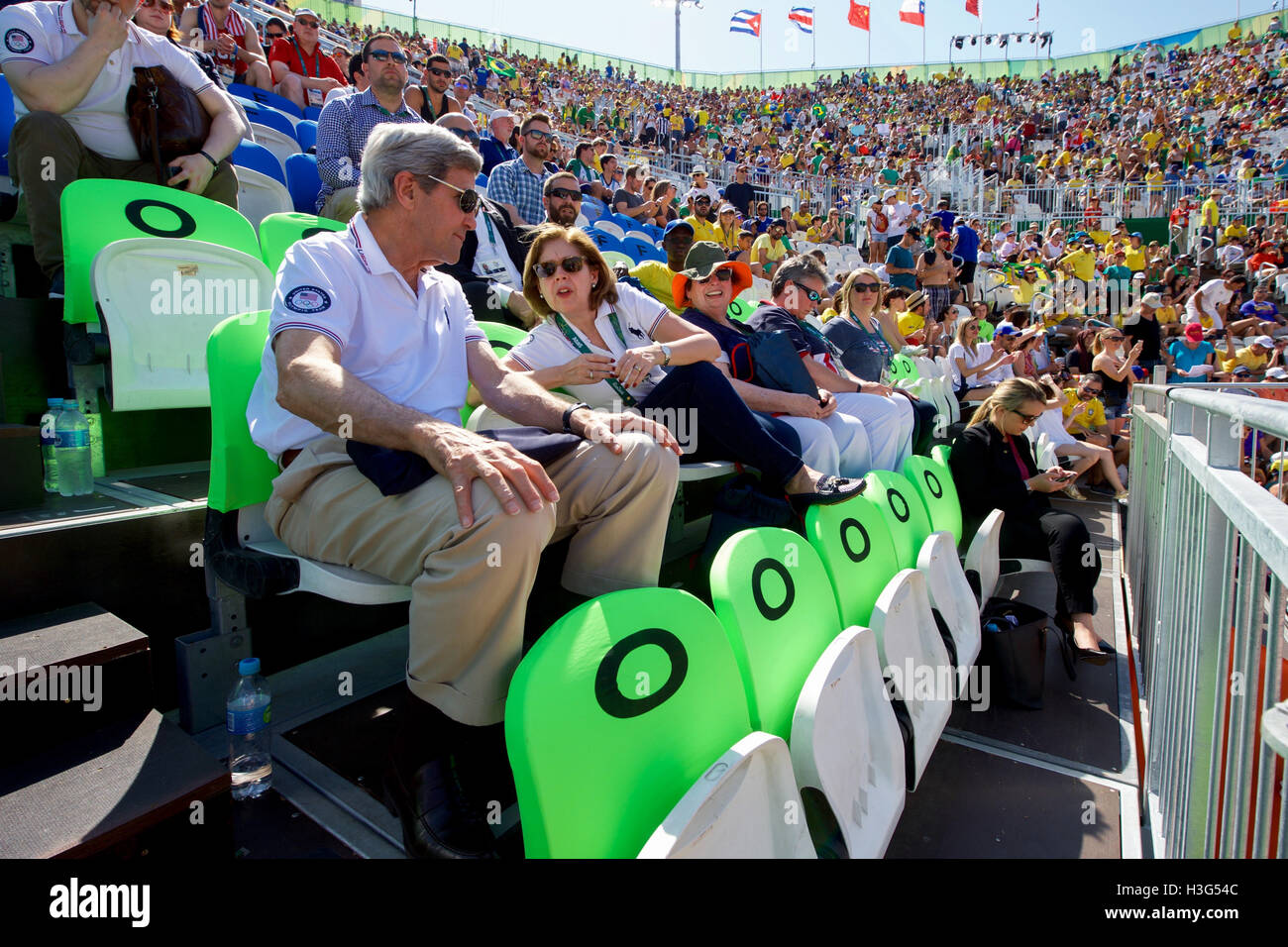 El Secretario de Estado de Estados Unidos, John Kerry habla con el embajador de Estados Unidos en Brasil Liliana Ayalde al ver un hombre Olímpico juego de voleibol playa en el Copacobana playa en Río de Janeiro, Brasil, mientras que ellos y sus colegas de la visita de la delegación presidencial de EE.UU. los Juegos Olímpicos de Verano el 6 de agosto de 2016. Foto de stock