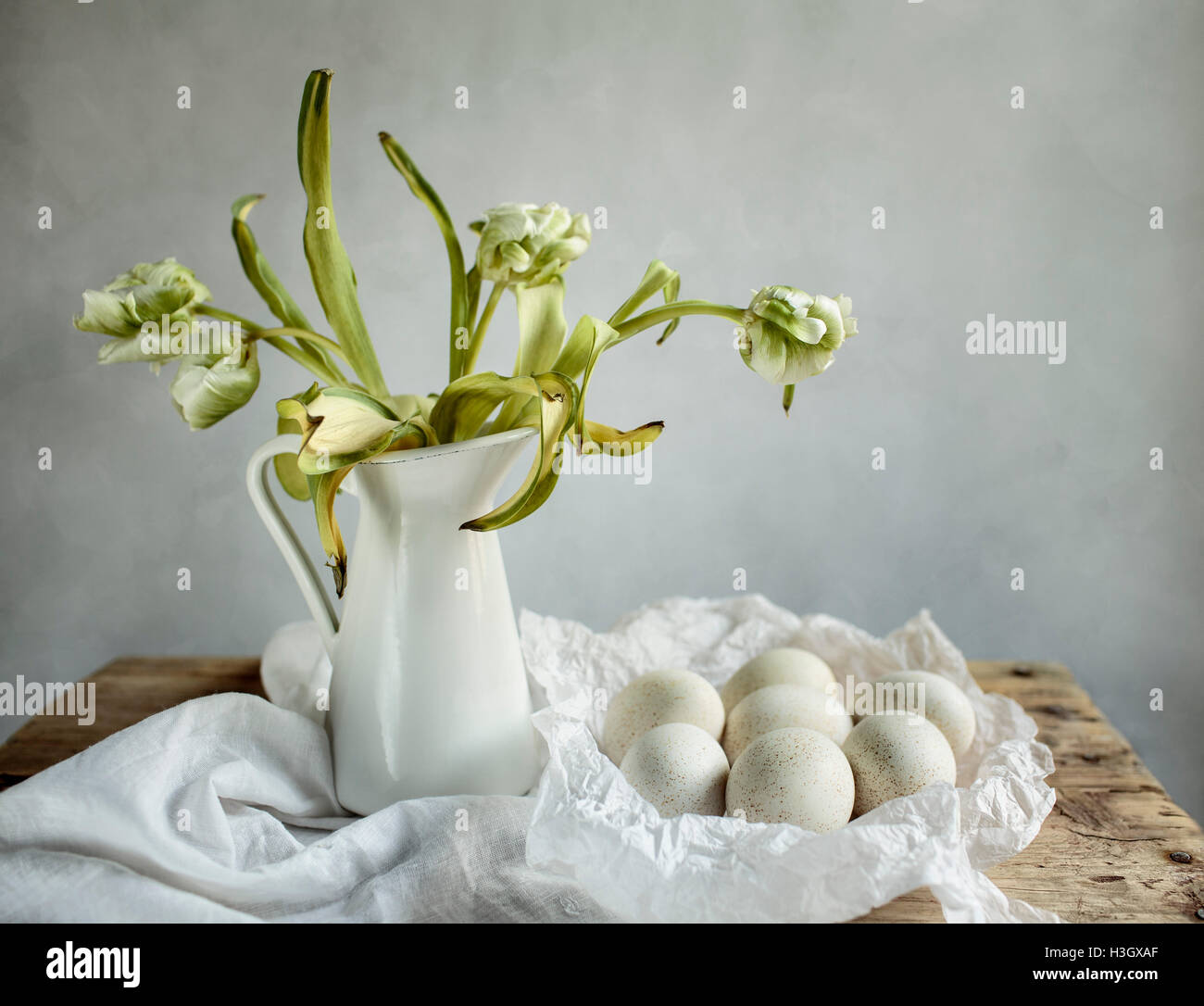 Bodegón con tulipanes y huevos de mesa de madera Foto de stock