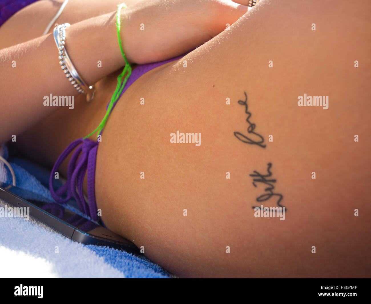 Una chica en bikini con una 'Con Amor' tatuaje Foto de stock