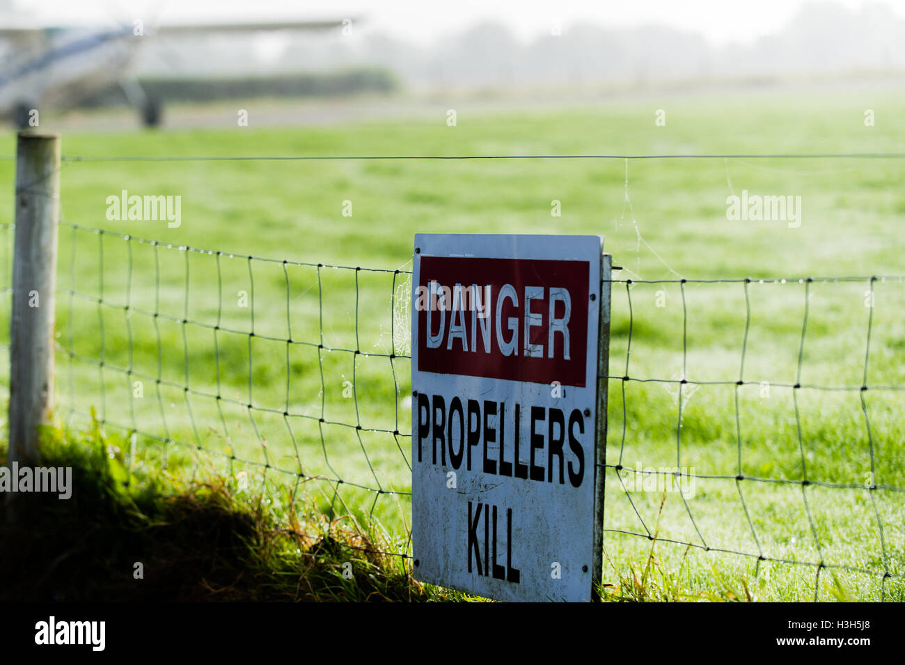 'Danger hélices matar" la señal de advertencia, con un avión Pilatus PC-6 Porter en el Irish Parachute Club en el condado de Offaly, Irlanda. Foto de stock