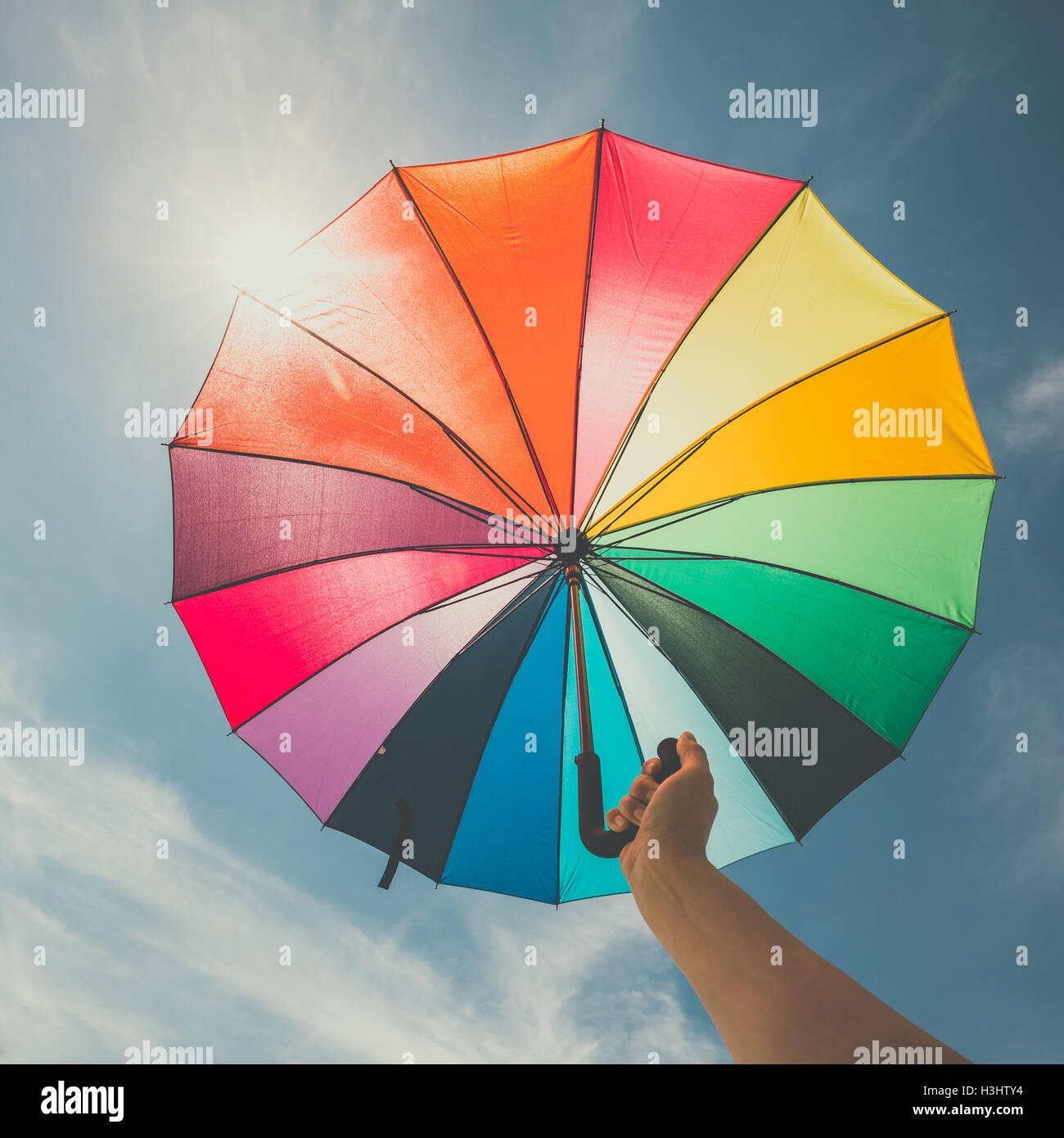 Abra coloridos paraguas rainbow sobre fondo de cielo azul, vintage buscar  Fotografía de stock - Alamy