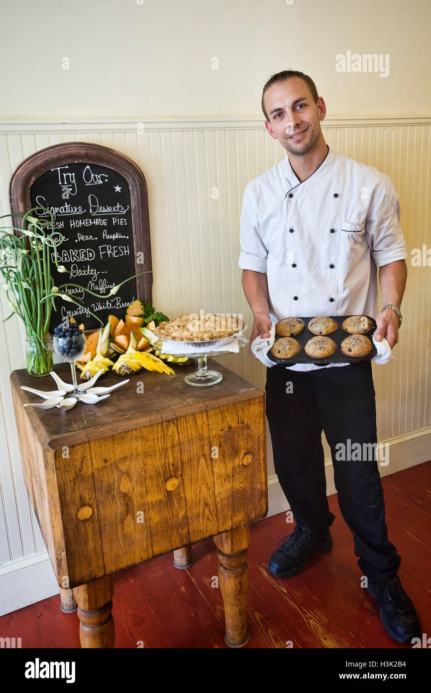 Chef con muffins frescos y pastel de mostrar la tabla Foto de stock