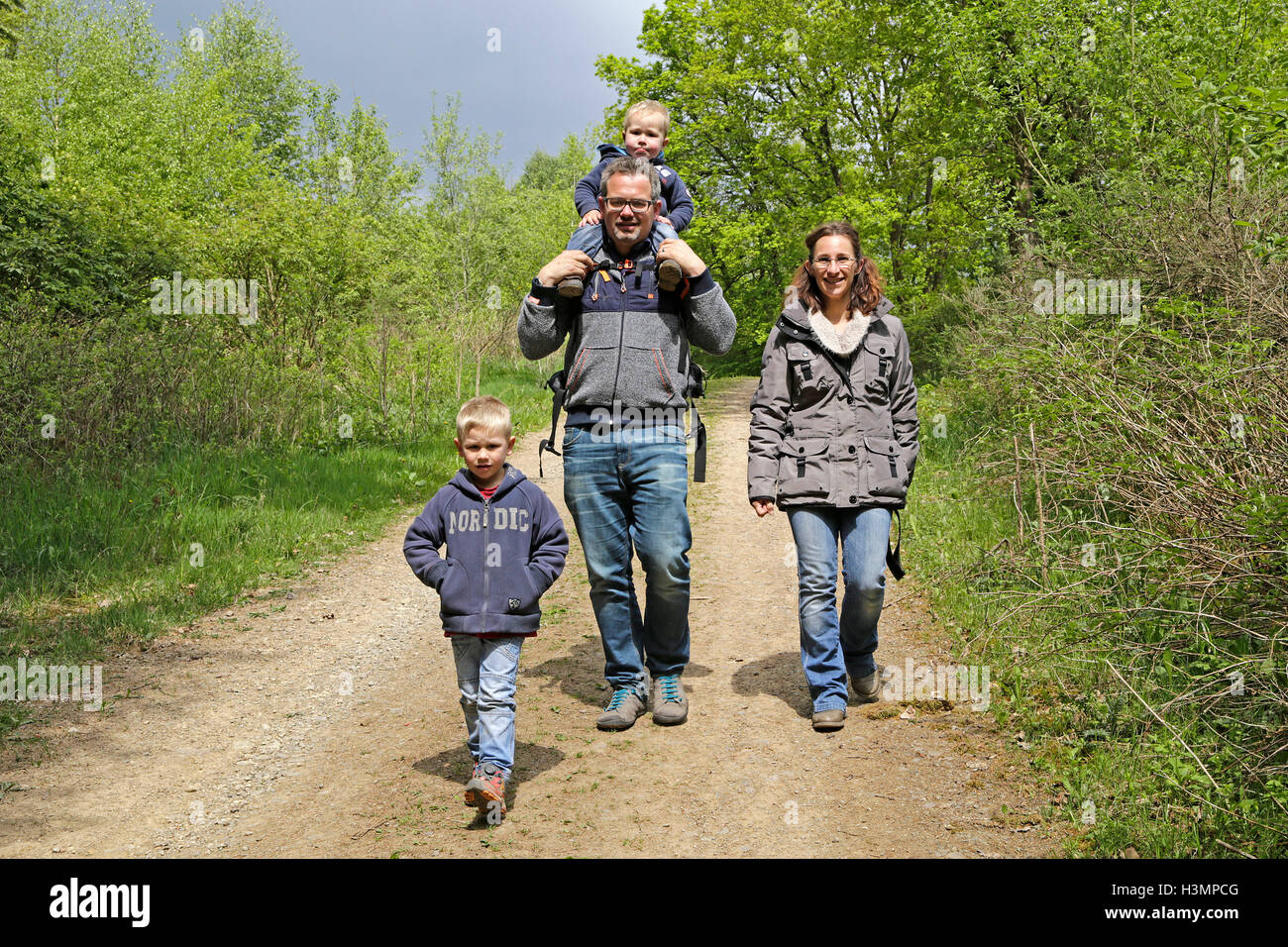 Familia joven va para caminar en el bosque Foto de stock