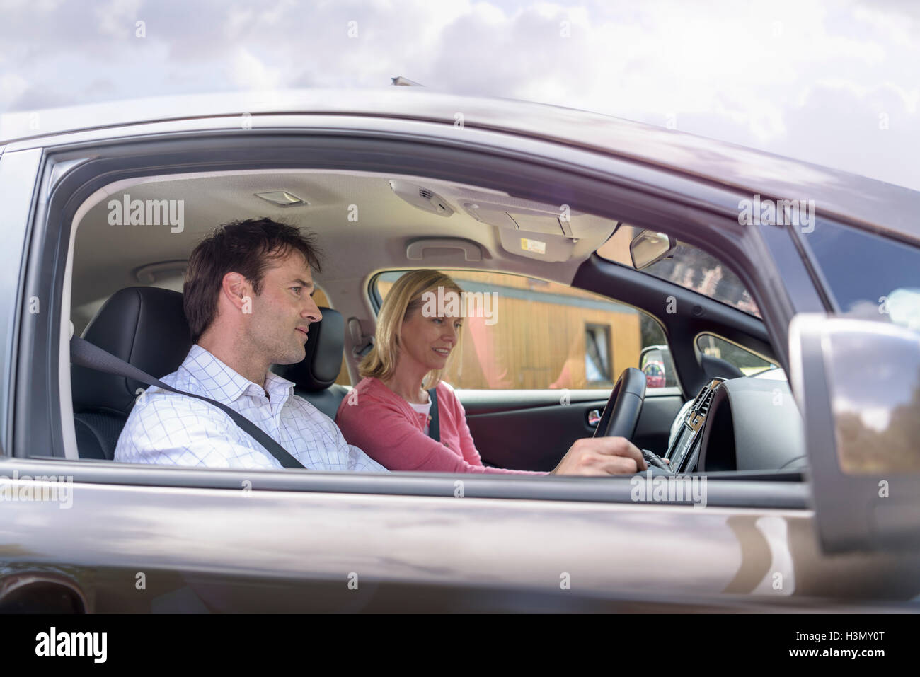 El hombre y la mujer en coche eléctrico Foto de stock