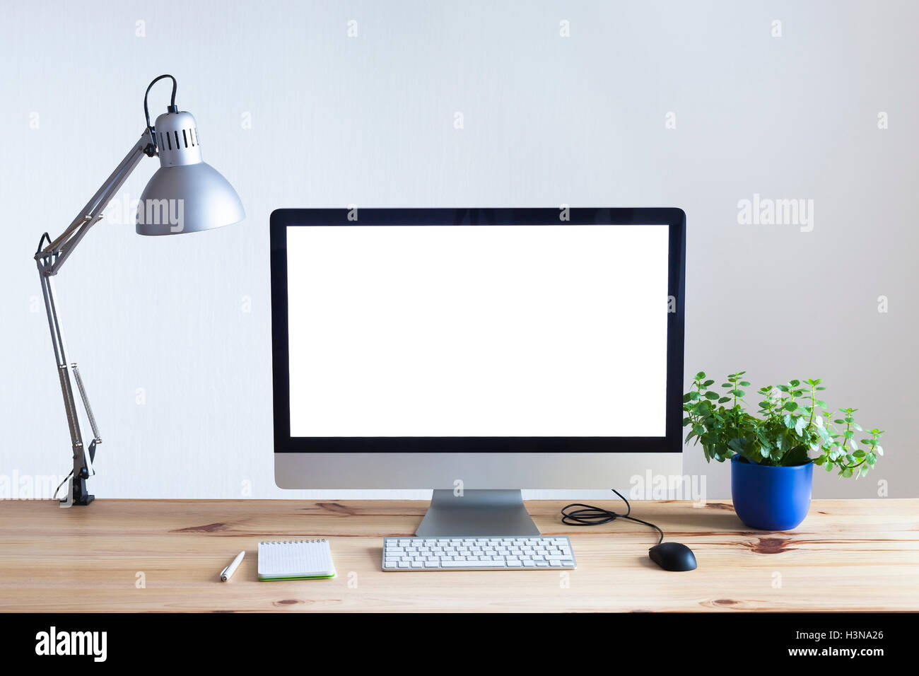Lámpara de monitor de computadora de pantalla en blanco blanca taza de café  y libros en la mesa de trabajo lugar de trabajo moderno