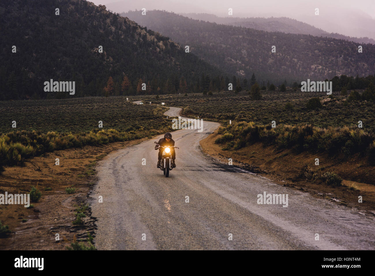 El motorista montando moto en carretera abierta, Kennedy Meadows, California, EE.UU. Foto de stock