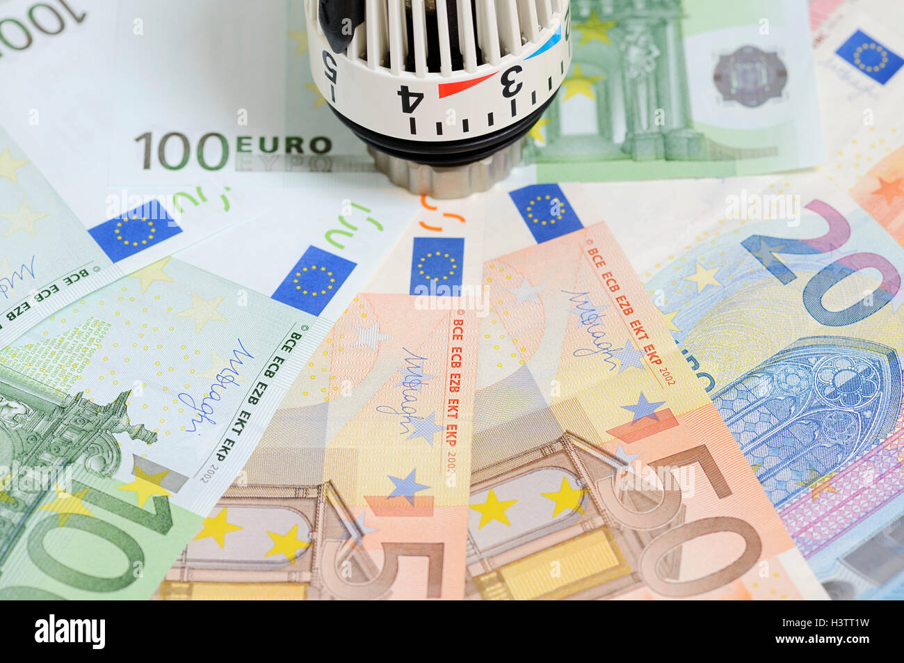 Varios billetes de euro y del termostato del radiador Foto de stock