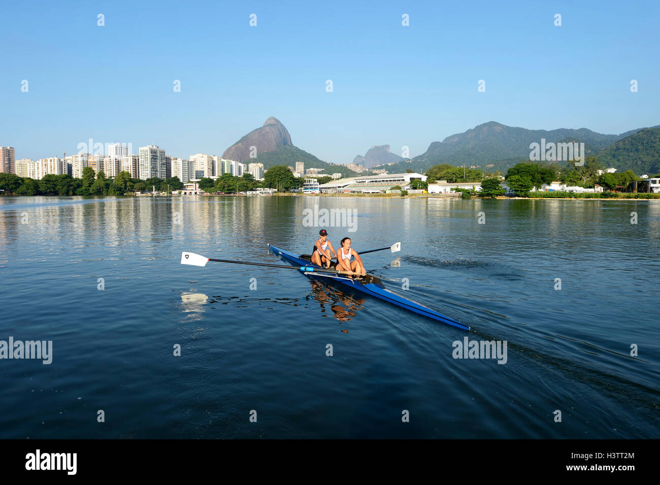 Dos mujeres jóvenes que participan en las primeras horas de la mañana en el entrenamiento de remo Lagoa Lagoa Rodrigo de Freitas, en Rio de Janeiro. Foto de stock