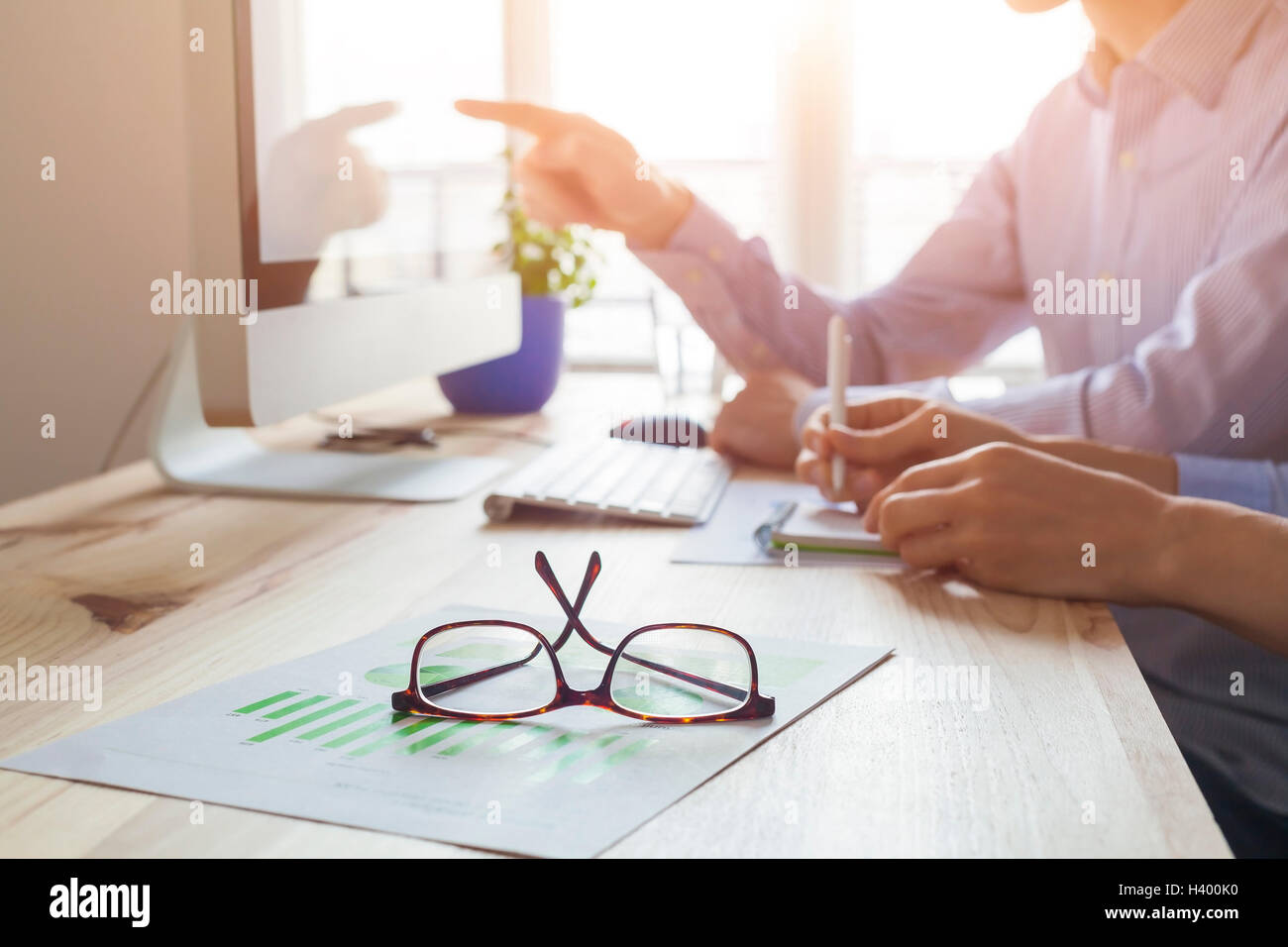 Puesta del sol en la atmósfera de trabajo co-oficina, reunión de negocios con dos personas, más cerca de las gafas Foto de stock