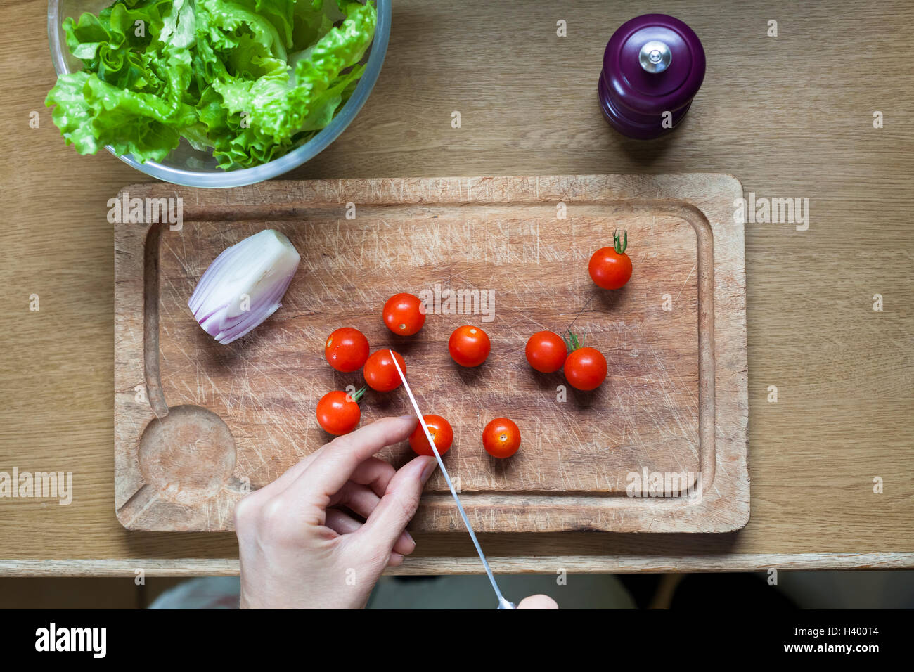 Preparación de ensaladas para dieta saludable en casa con tomates cherry Foto de stock
