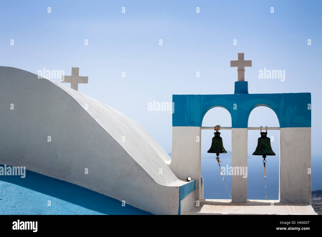 Impresionante iglesia griega tradicional con paredes pintadas de azul y blanco y campanas en una pequeña aldea en la isla de Santorini, Cyclades Foto de stock