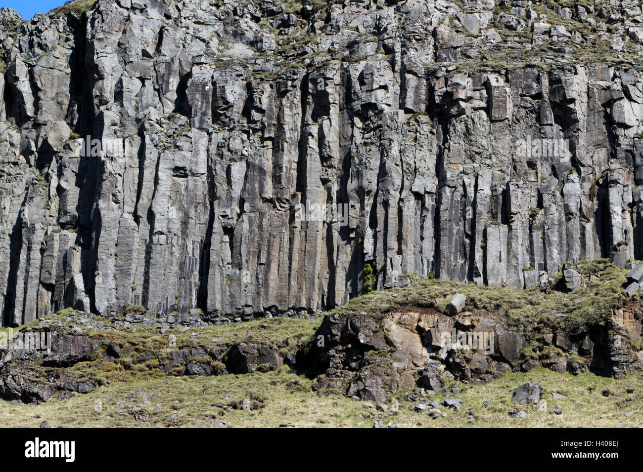 Columnas de basalto formaciones de roca volcánica en acantilados cerca del mar Islandia Foto de stock
