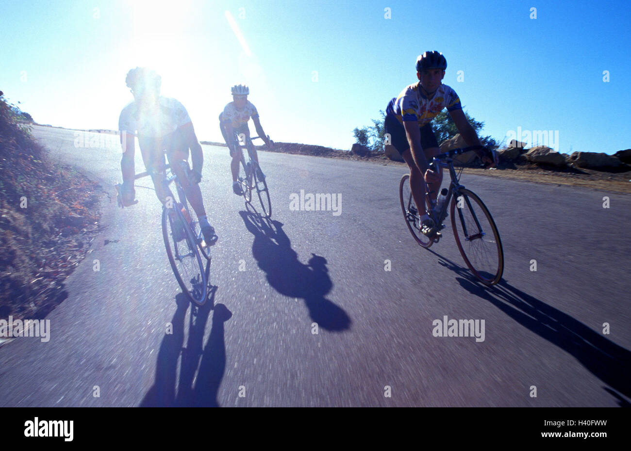 Carretera de montaña, carrera ciclista, circulando en una bajada, Back light street, ciclista, volantes de carreras, grupo, equipo racing radián, paseos en bicicleta, unidad Rennradfahren, bicicletas, ropa, cascos de bicicleta, uno tras otro, de formación, de excursión en bicicleta, bicicletas, conducción Foto de stock