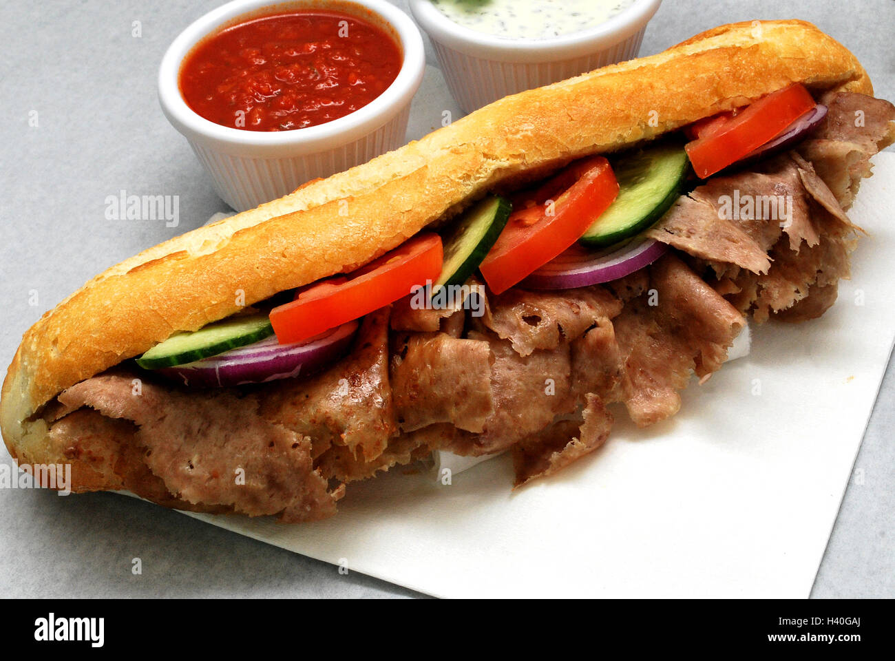 Doner kebab de cordero en baguettes con ensalada, salsa de chili, salsa de ajo Foto de stock