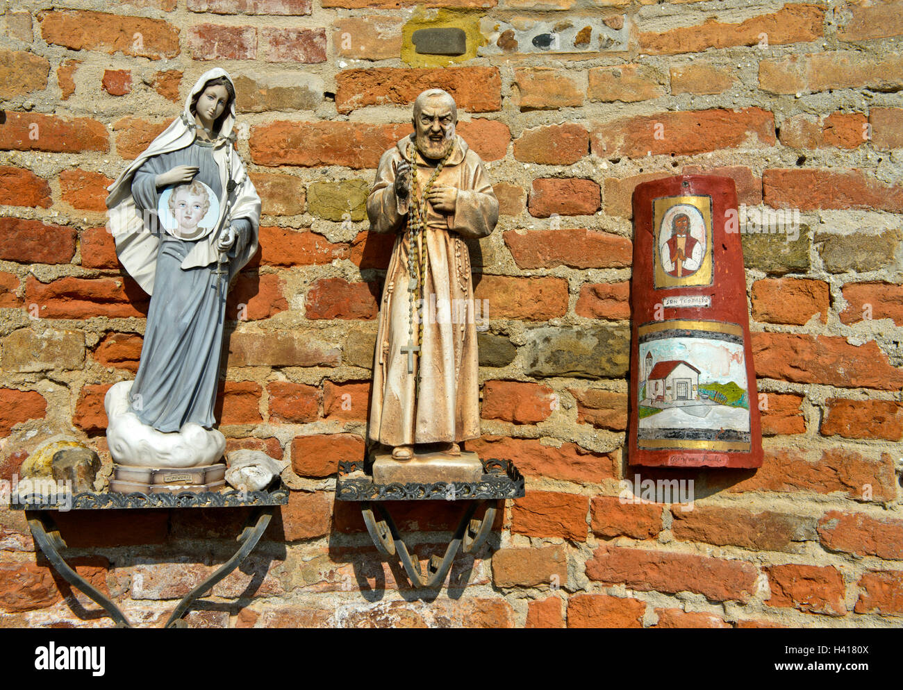 Las estatuas de la Virgen y de un monje en la Iglesia de San Giovanni Battista, Barbaresco, provincia de Cuneo, Piamonte, Italia Foto de stock