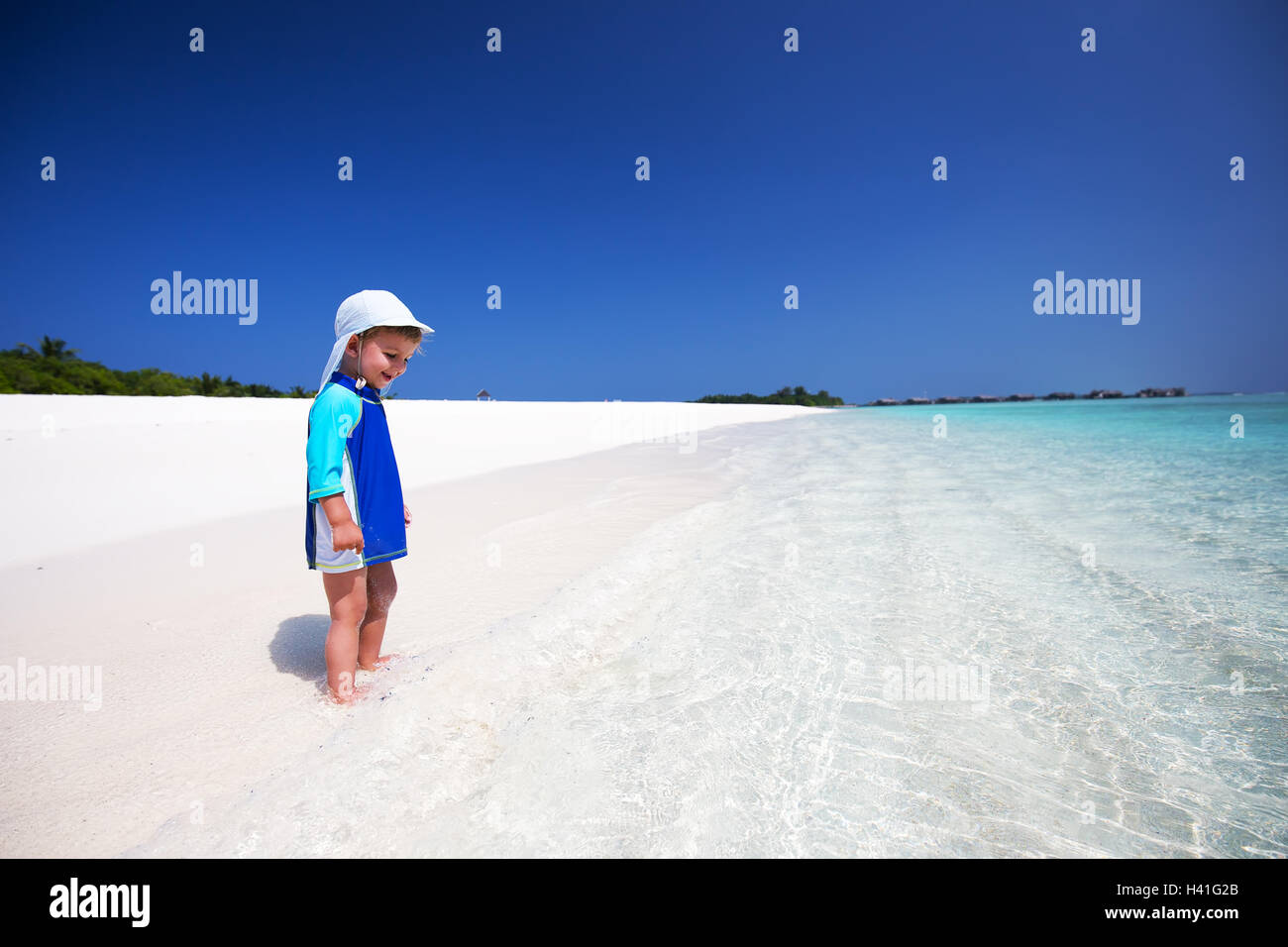 Chico divirtiéndose en la playa tropical Foto de stock