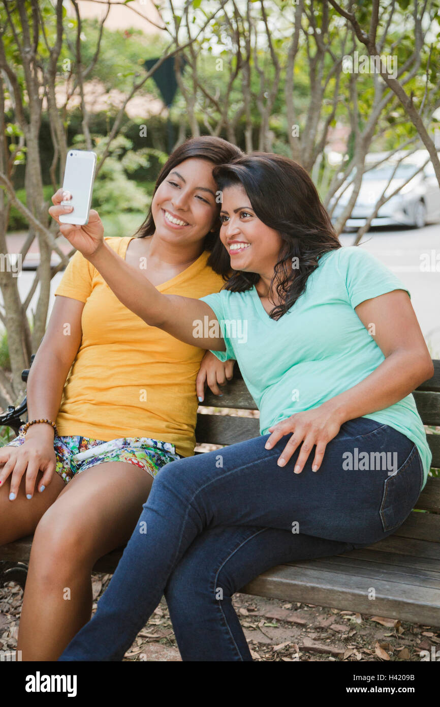 Hispanic madre e hija posando para teléfono celular selfie Foto de stock