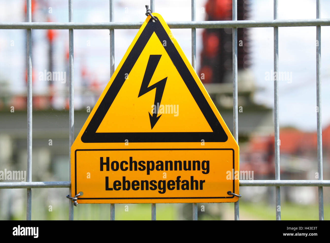 Señal de advertencia, Hochspannung Lebensgefahr, alta tensión peligro de muerte en alemán, sobre la valla metálica en una subestación eléctrica Foto de stock
