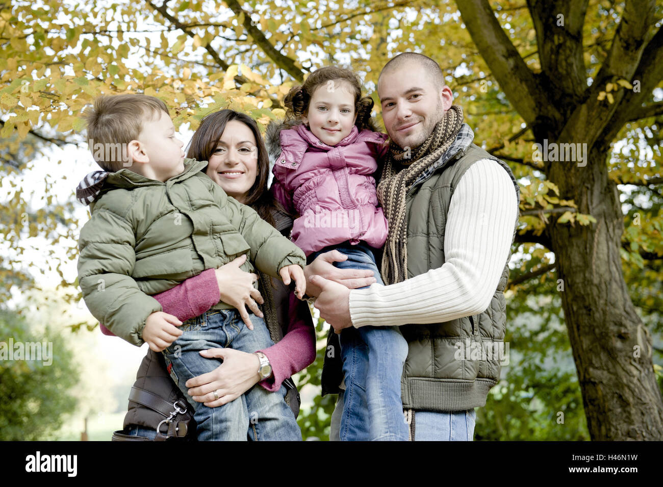 Los padres y dos hijos en otoño. Foto de stock