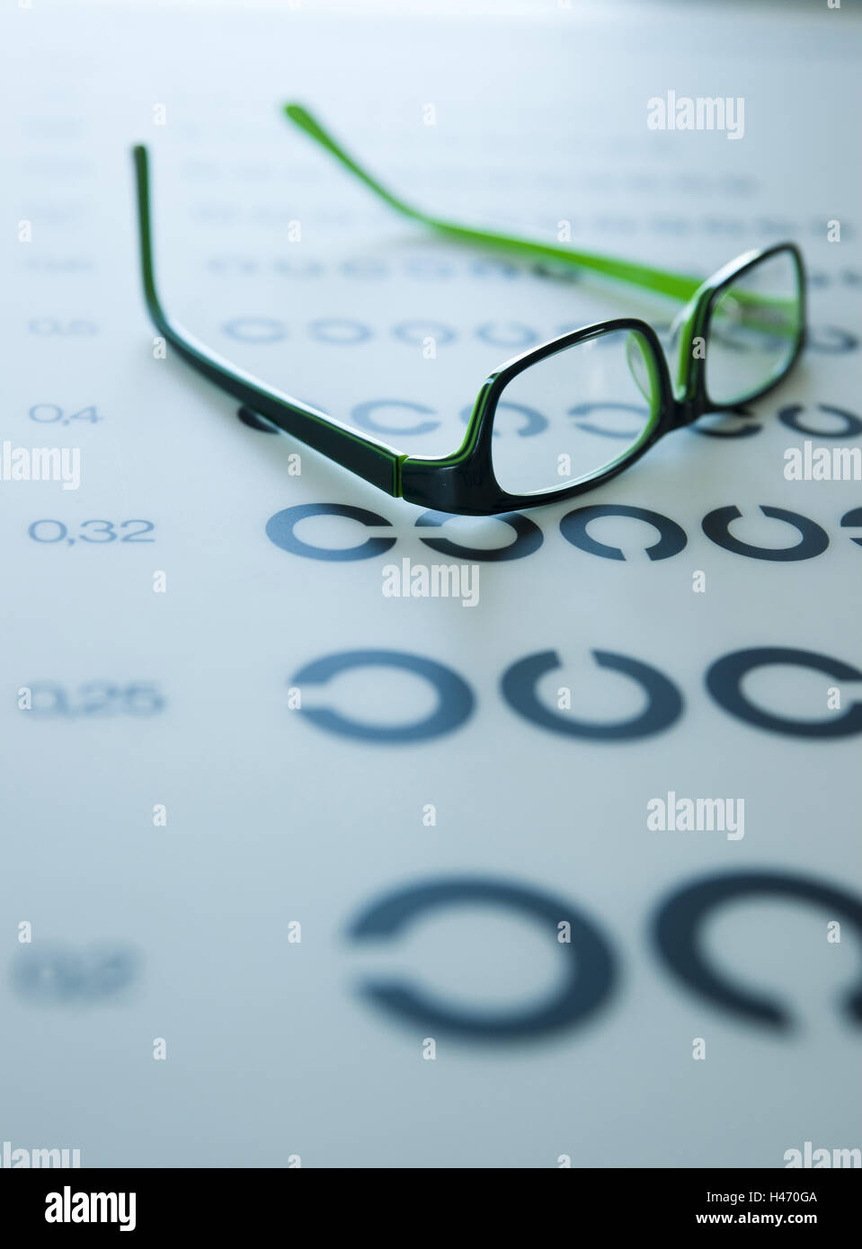 Un par de gafas yace sobre una prueba visual de tablón de anuncios, Foto de stock