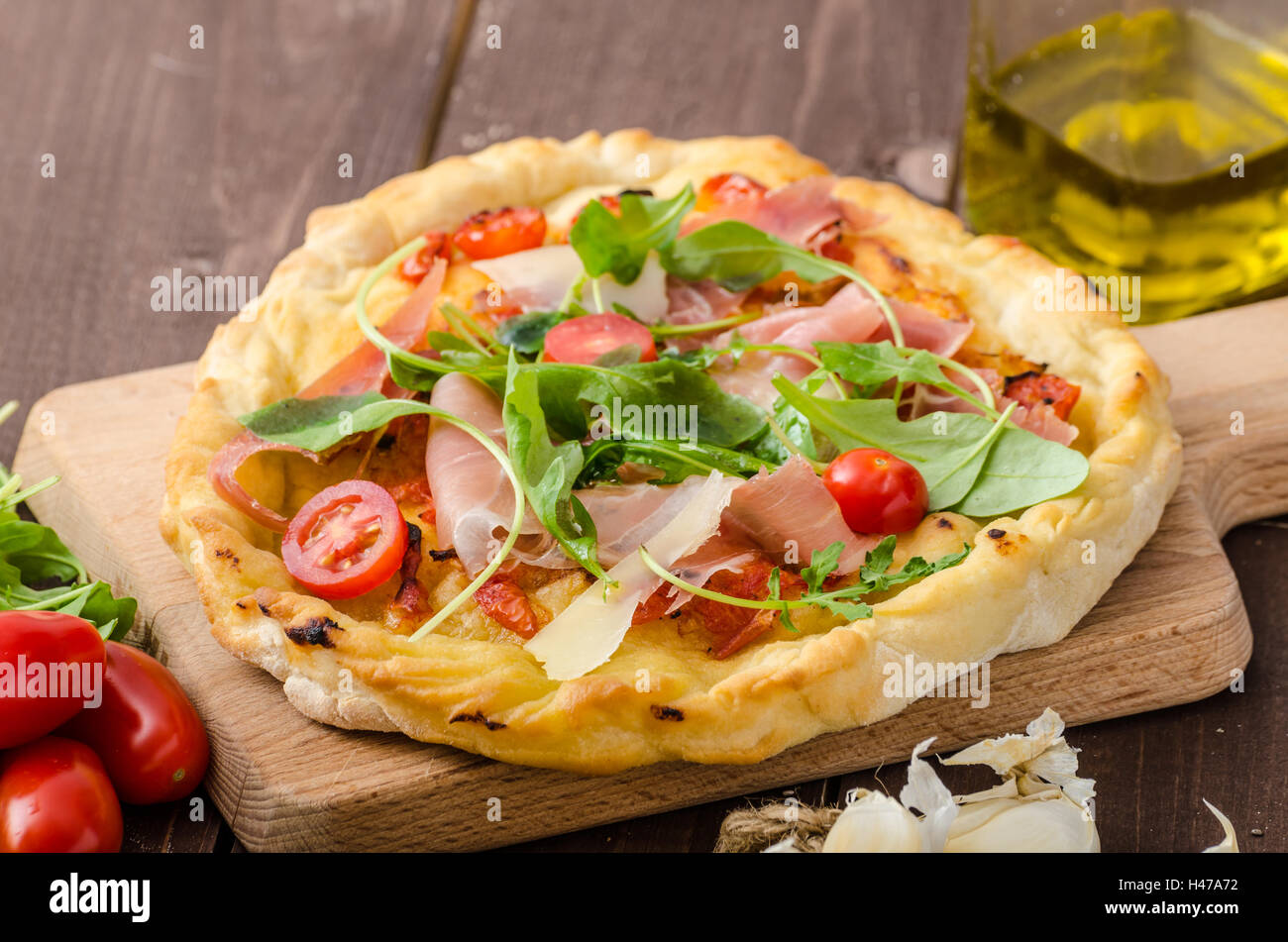 Pizza italiana con queso parmesano, jamón serrano y rúcula, hecho en