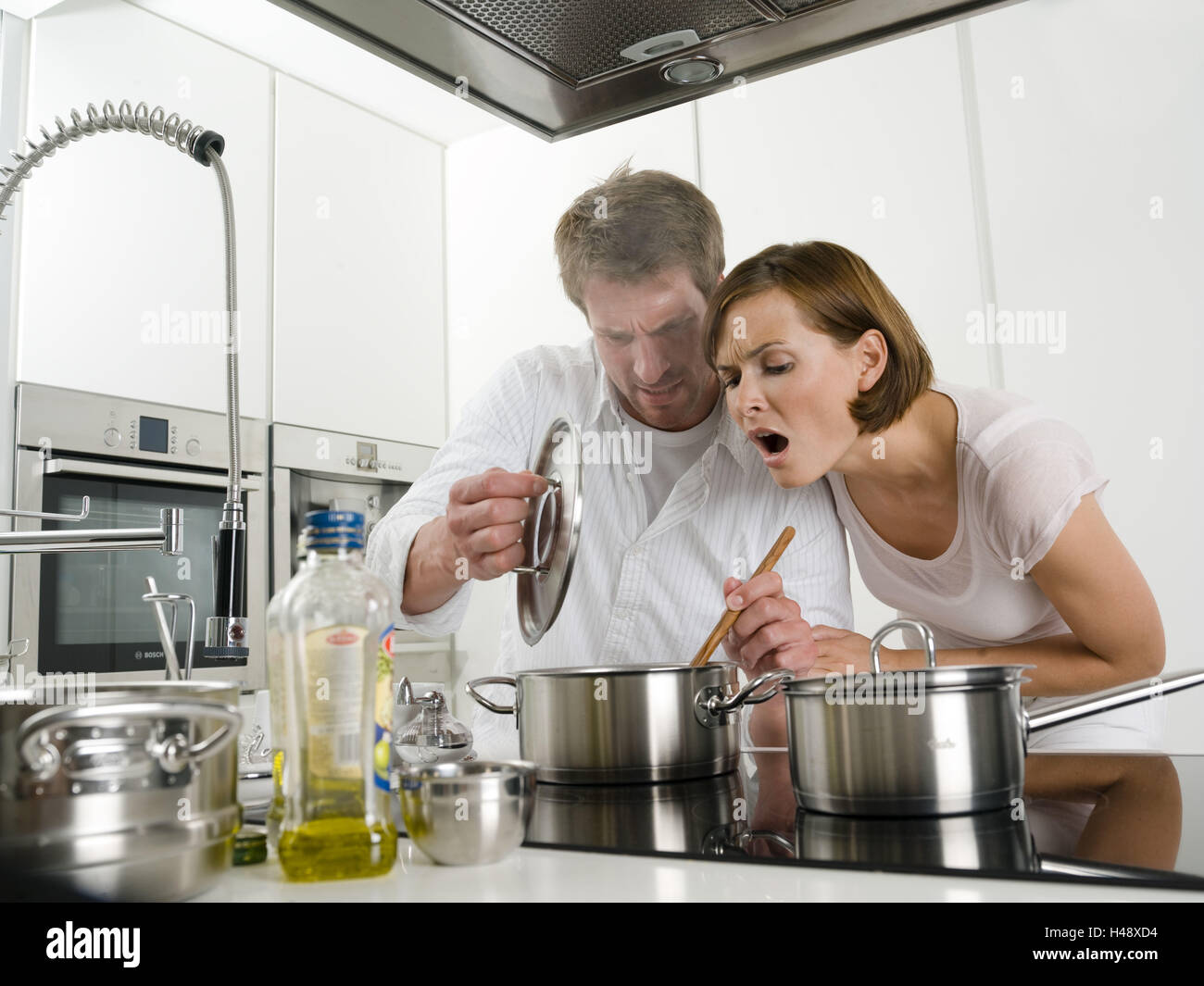 Pareja joven, cocina, cocina, sartén, causa horror Fotografía de stock - Alamy Pareja joven, cocina, cocina, sartén, causa horror Fotografía de stock - Alamy