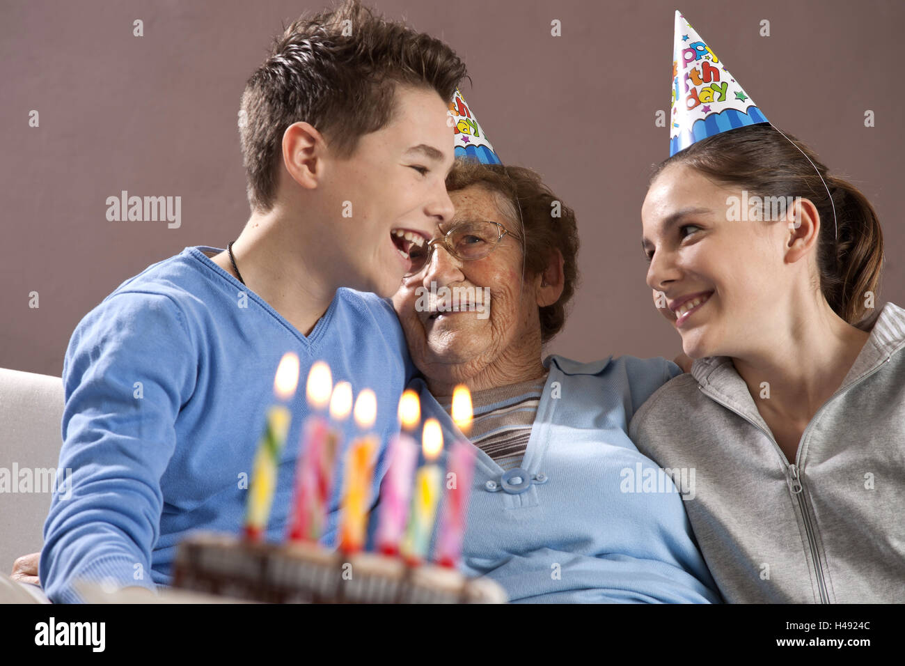 Nieto y nieta celebrar con su abuela cumpleaños Foto de stock