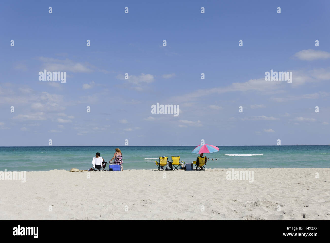 Mujer sentada sobre cool box, vida de playa, playa el párrafo, sutura 77 Street, Miami South Beach, Atlantic, Florida, Estados Unidos. Foto de stock