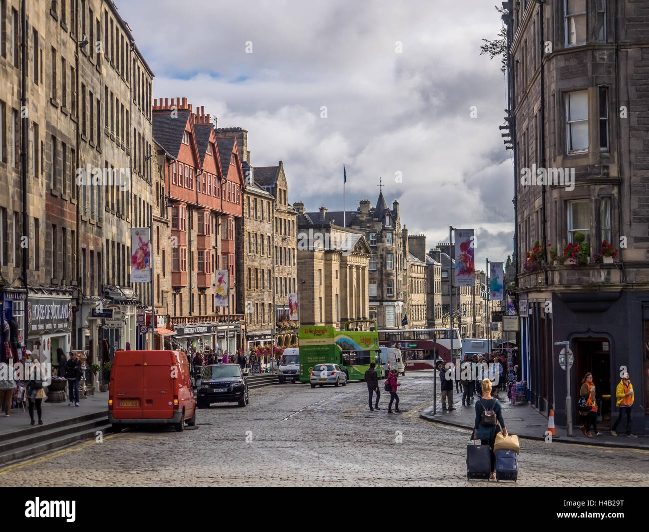 Edimburgo, Escocia - 02 Septiembre 2016 : Mujer jalando maletas de equipaje y turistas en la calle en el casco antiguo de Edimburgo Foto de stock