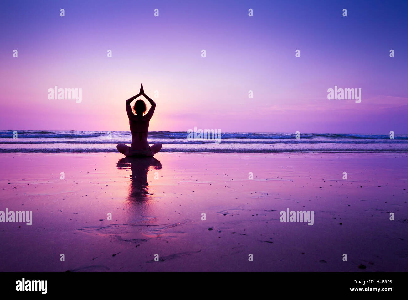 Mujer practicando yoga en la playa al anochecer en Koh Chang, Tailandia Foto de stock