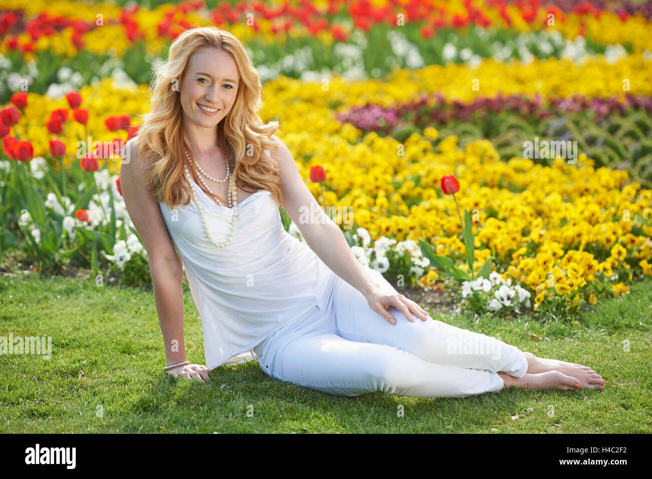 Mujer, jóvenes, pradera, sentado, al parque de la ciudad Foto de stock