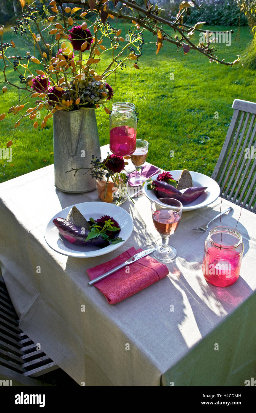 Mesa de jardín cubierto en el sol de la tarde Foto de stock