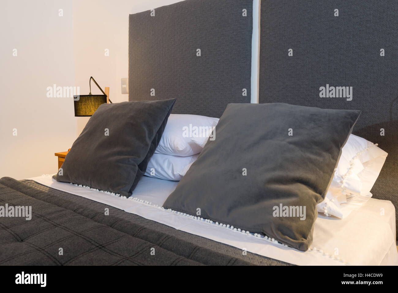 Almohadones decorativos de acuerdo con cama dormitorio lámparas y mesitas de  noche Fotografía de stock - Alamy