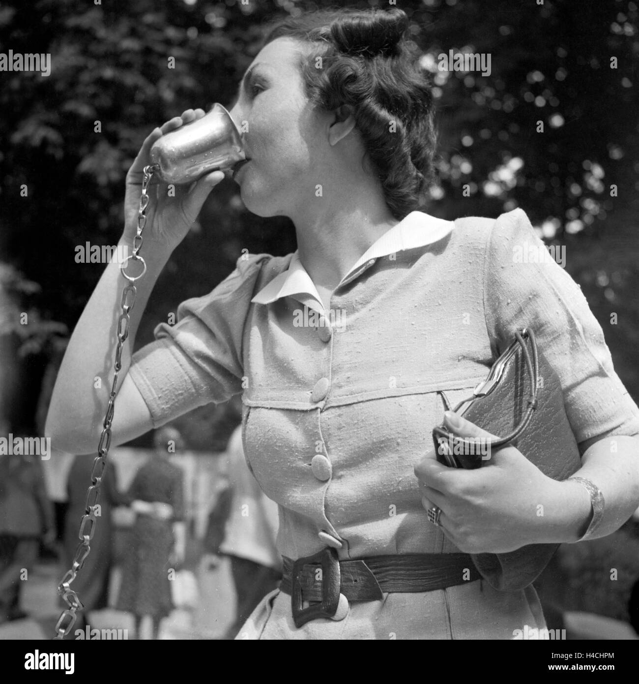 Eine Frau Aus einem trinkt Brunnen en Bei Stuttgart Bad Cannstatt, Deutschland 1930er Jahre. Una mujer bebiendo de un pozo en Bad Cannstatt, cerca de Stuttgart, Alemania 1930. Foto de stock