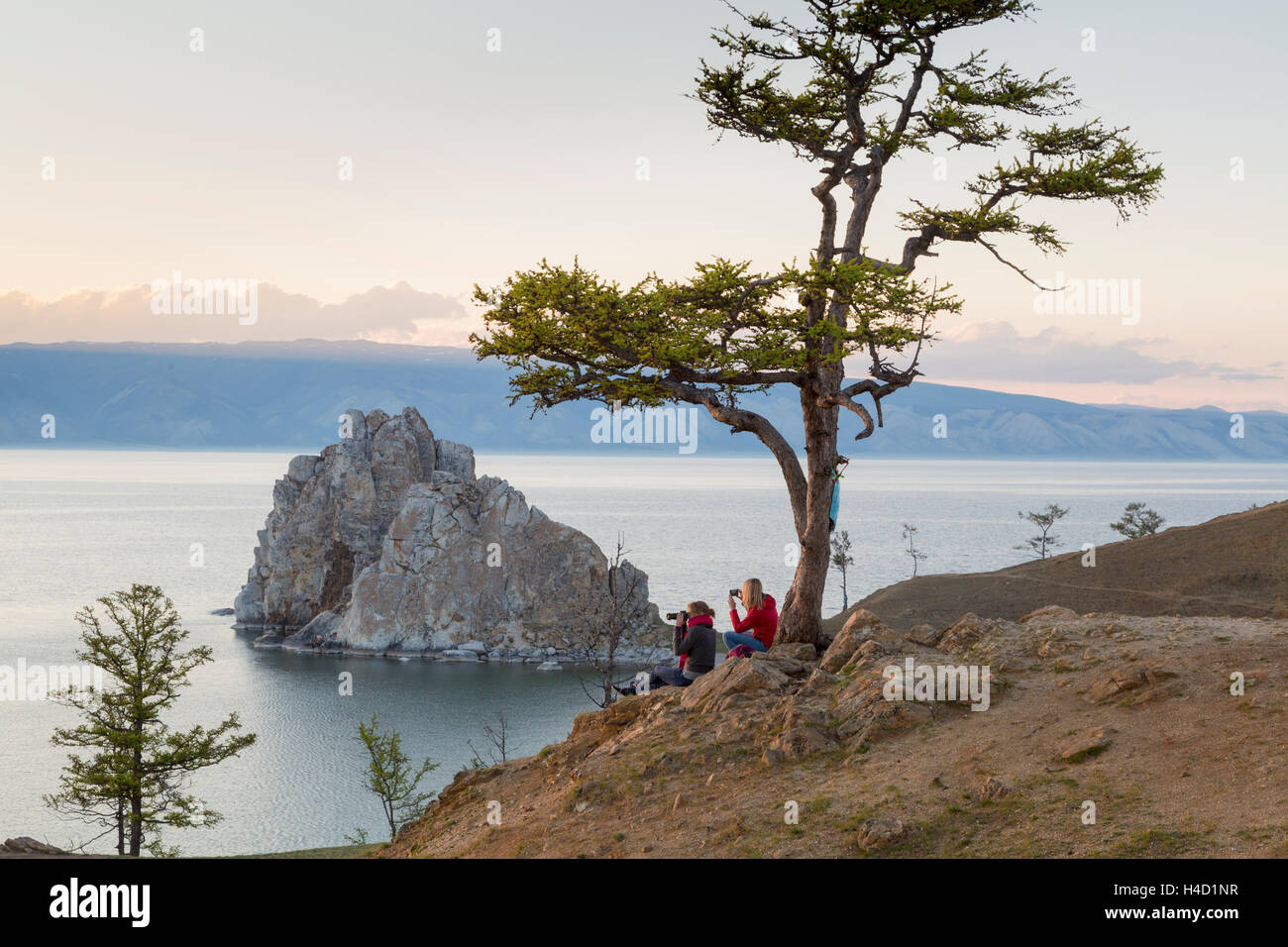 Los turistas observan costa del lago Baikal, el Chamán rock, el árbol de los deseos y el cabo Burhan en la isla Olkhon en Rusia Foto de stock