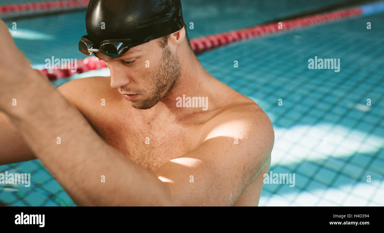 Primer plano de atleta masculino profesional apoyado sobre el borde de la piscina. Joven en la piscina. Foto de stock