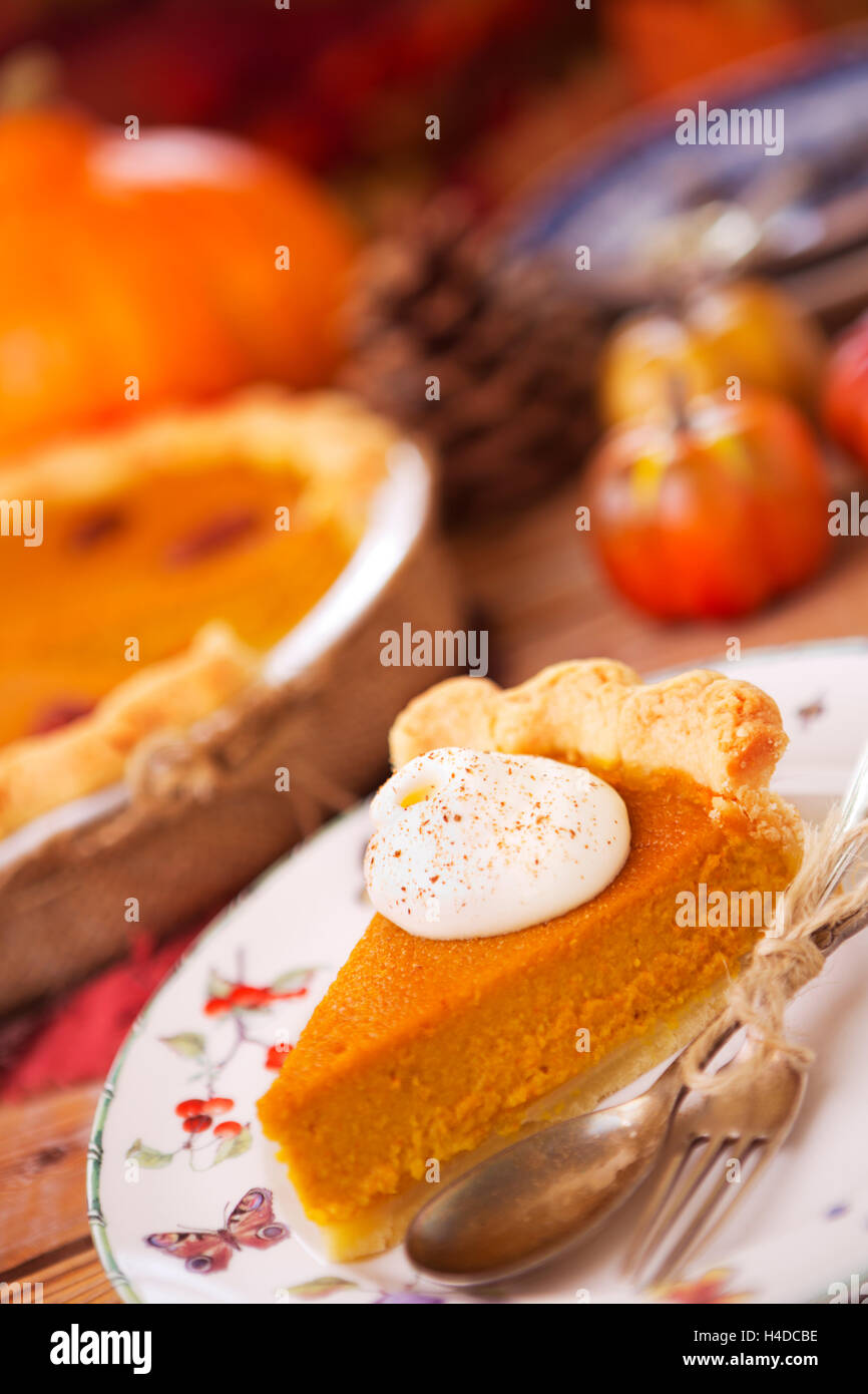 Pastel de calabaza casero sobre una mesa rústica con decoraciones de otoño. Foto de stock