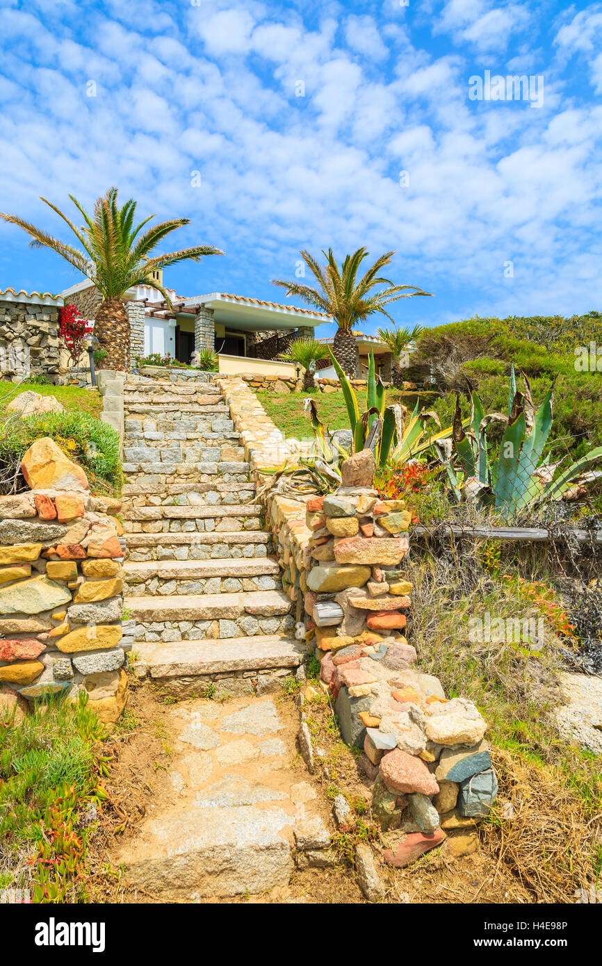 Pasarela de piedra de casa de vacaciones en la costa de la isla Cerdeña visto desde la ruta costera, Italia Foto de stock