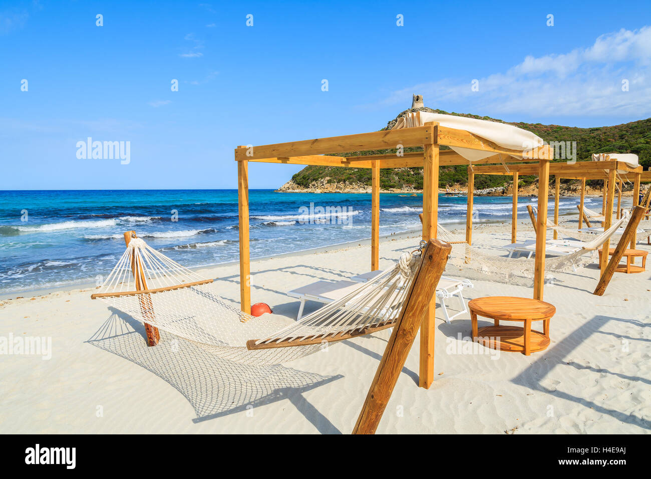 Hamacas en la playa de arena blanca en la bahía de Porto Giunco, Cerdeña, Italia Foto de stock