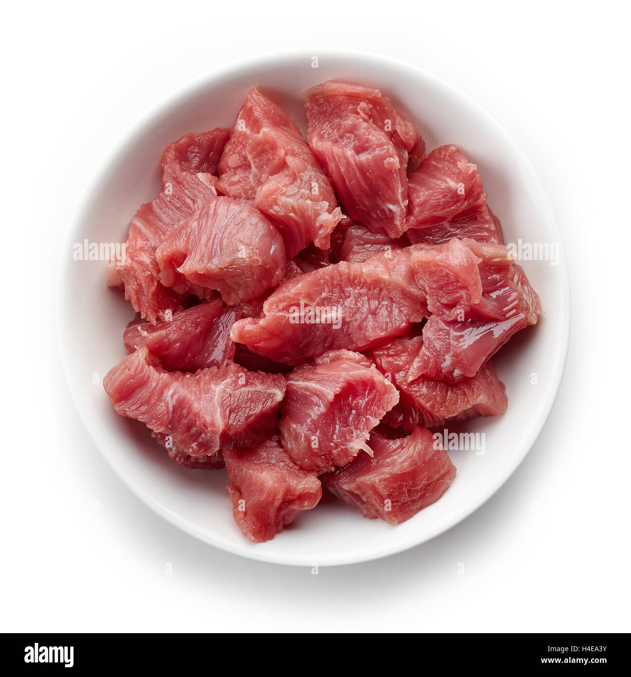 Tazón blanco de trocitos de carne cruda aislado sobre fondo blanco, vista superior Foto de stock