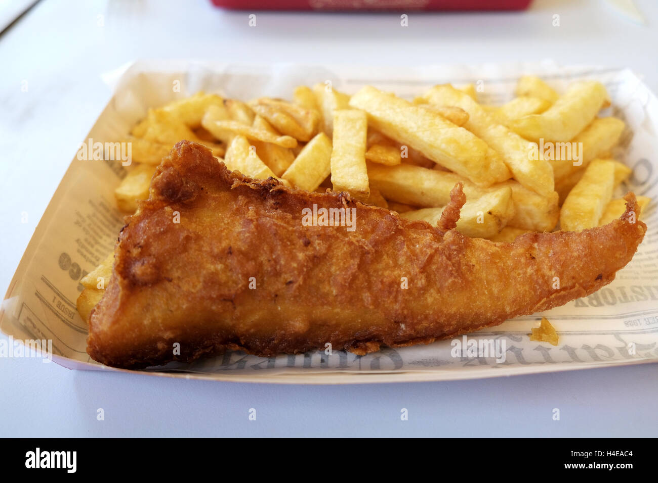 Una porción de pescado y patatas fritas recién cocinados desde un Harry Ramsden fish and chips shop Foto de stock